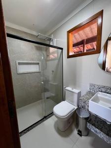 a bathroom with a shower and a toilet and a sink at quarto quadruplo 8 in Guarapari