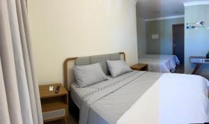 a hotel room with a bed and a couch at quarto quadruplo 8 in Guarapari