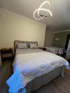 a bedroom with a large bed and a light fixture at quarto quadruplo 8 in Guarapari