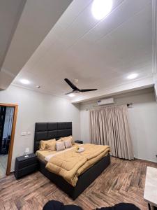 a bedroom with a bed and a ceiling fan at Designer 1 bedroom , self check-in , pool & sauna in Rawalpindi