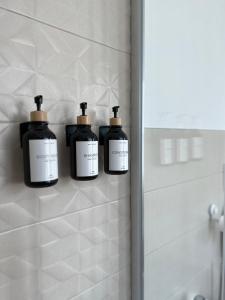 drie flessen zeep op een muur in een badkamer bij Central Apartment in Matera