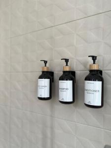 drie flessen zeep hangen aan een muur bij Central Apartment in Matera
