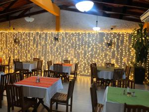a dining room with tables and chairs and a wall with lights at Hotel Mitru - Tarija in Tarija