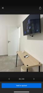 een kamer met een tafel en een tv aan de muur bij Central Apartment in Matera +70 foto's