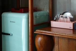 a blue refrigerator next to a wooden table next to a counter at Paradox in Thessaloniki