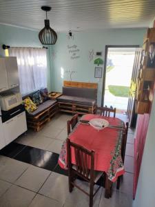 a dining room with a table and a couch at Casa Recanto do Baiano in Balneário Gaivotas +7 photos