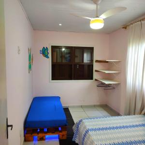 a bedroom with a blue bed and a window at Casa Recanto do Baiano in Balneário Gaivotas