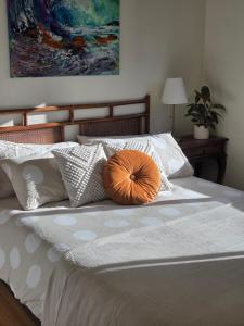 a large bed with a large orange pillow on it at Cosy Brick Beachouse - ALL INCLUDED in Inverloch