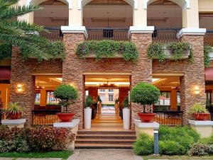 a brick building with potted plants in front of it at Janna's Condo Hotel in Cebu City
