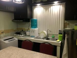 a kitchen with a sink and a counter top at Janna's Condo Hotel in Cebu City