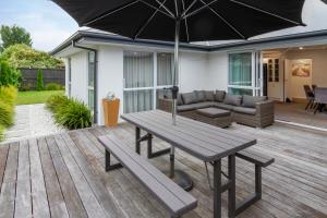 a wooden deck with a picnic table and an umbrella at Spacious 3BR with 2 carpark in Lincoln