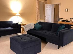 a living room with a black couch and a ottoman at Mordor Lodge in Braunton +56 photos