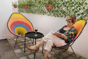 a woman sitting in a chair reading a book at Santuario De Luna, Departamento in Cholula +33 photos