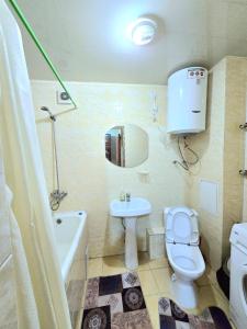 a bathroom with a toilet and a sink and a tub at Аэропорт Астана 5 минут 1 in Astana