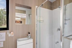 een badkamer met een douche, toilet en wastafel bij Inana Shanti by Tiny Away in Cooranbong +16 foto's