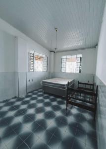 an empty room with a bed and two windows at Recanto Sossego I in Tucano