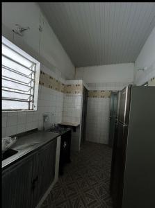 a small kitchen with a refrigerator and a sink at Recanto Sossego I in Tucano