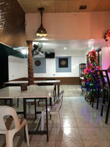 a restaurant with tables and chairs and a christmas tree at Skipper Joes Resort in Dauis