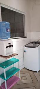 een keuken met een magnetron en een kleine koelkast bij Casa temporada Guriri Regi 2 in São Mateus