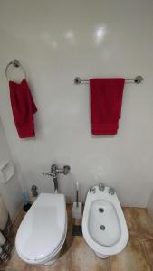 a bathroom with a toilet and two red towels at Torre Obelisco - Apart 2 Amb en Av Corrientes, Buenos Aires, Argentina in Buenos Aires +14 photos