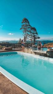 a group of people standing around a swimming pool at Chalé Refugio nas montanhas in Guaratuba
