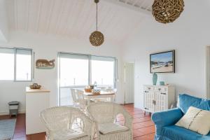 a living room with a blue couch and chairs at Quo Mosteiros Sunset House in Mosteiros +27 photos