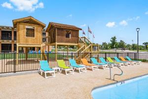 a row of chairs next to a swimming pool at Roark Home Suites - Branson Landing, Gym, Indoor Pool in Branson