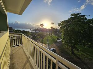 a balcony with a view of the ocean and palm trees at L'Echappée Créole - Vue mer Terminal Ferry - Pointe-à-Pitre in Pointe-à-Pitre