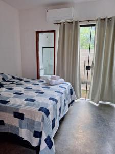 a bedroom with a bed with a blue and white checked blanket at Suíte Recanto dos poetas 06 in Lençóis