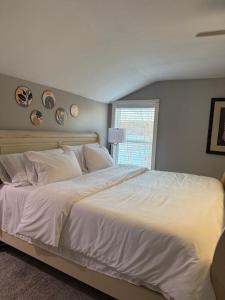 een groot wit bed in een slaapkamer met een raam bij Cozy lake house in Nassau