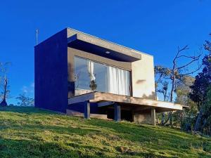 a house on top of a grassy hill at Chalé Refugio nas montanhas in Guaratuba