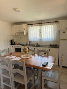 a kitchen with a wooden table and chairs and a kitchen with a refrigerator at Merlinda in Merlo