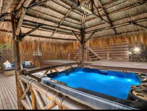 a large hot tub in a thatched hut at Mountain View Spa Cottage in The Basin