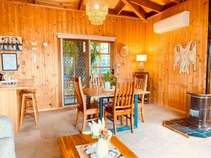 a dining room with a table and wooden walls at Mountain View Spa Cottage in The Basin