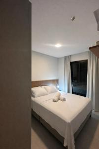 a bedroom with a bed with two towels on it at Flat novo próximo ao Hard Rock in Itapema