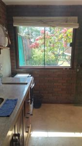 a kitchen with a large window in a room at Edícula 2 quartos frente mar in Ilhéus