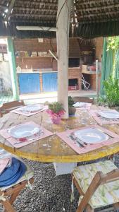 a wooden table with plates on top of it at Edícula 2 quartos frente mar in Ilhéus