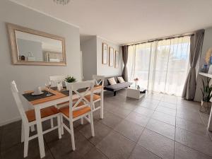 a dining room and living room with a table and chairs at Arriendo dpto avenida del Mar. in La Serena