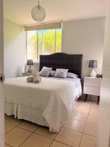 a bedroom with a large bed and a window at Arriendo dpto avenida del Mar. in La Serena