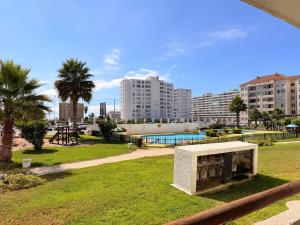 a park with a fireplace in the grass with buildings at Arriendo dpto avenida del Mar. in La Serena