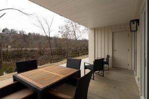 a porch with a wooden table and chairs on a porch at Roark Home Suites - Branson Landing, Gym, Indoor Pool in Branson