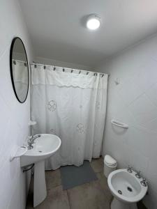 a bathroom with a sink and a toilet and a mirror at Merlinda in Merlo +2 photos