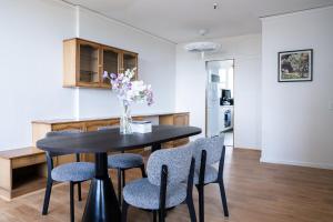 a dining room table with chairs and a vase of flowers at Central CBD High-Level Apartment with Views in Sydney