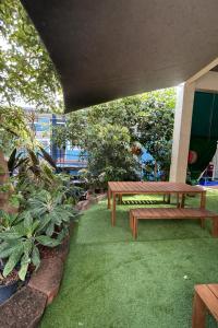 een picknicktafel en een bankje op het gras bij Zen Hostel in Townsville