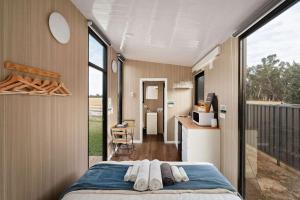 una camera da letto con un letto con asciugamani sopra di Murray Haven Farm Stay by Tiny Away a Koonoomoo