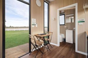 una cucina con tavolo e sedie in una casa di Murray Haven Farm Stay by Tiny Away a Koonoomoo Altre 13 foto