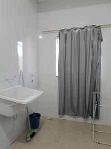 a bathroom with a sink and a shower curtain at Kitnet amplo in Santa Cruz Cabrália