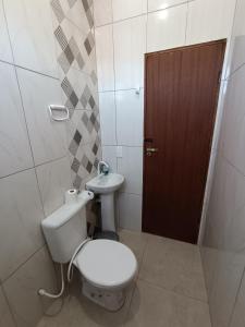 a bathroom with a toilet and a sink at Kitnet amplo in Santa Cruz Cabrália