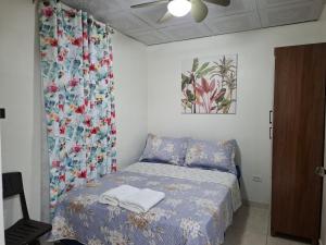 a bedroom with a bed with a blue comforter at Casa Lilia 10 minutos Aeropuerto Tocumen in Panama City