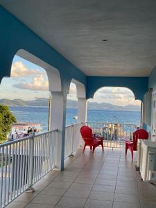 a balcony with chairs and a view of the ocean at Sea View Escape in The Valley